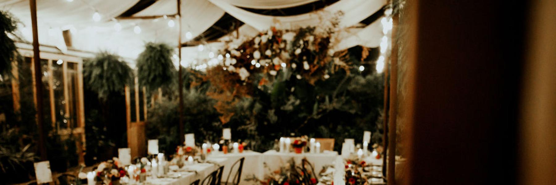 wedding reception tables with candles, flowers, and table settings