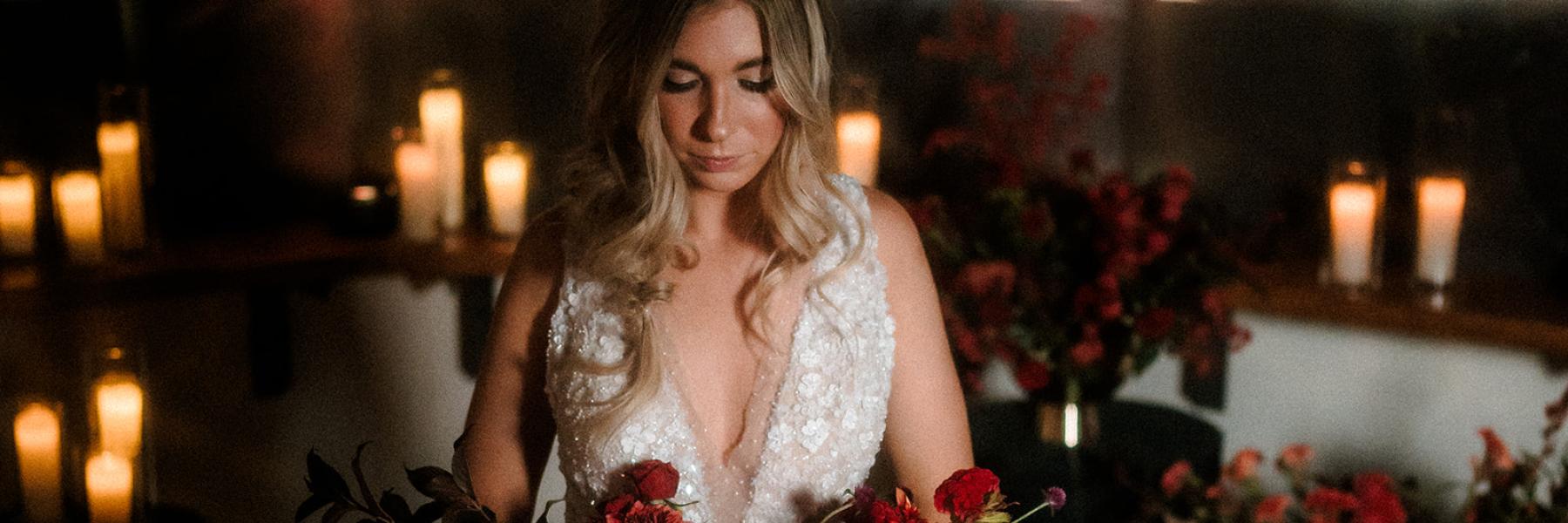 bride holding bouquet of all red flowers