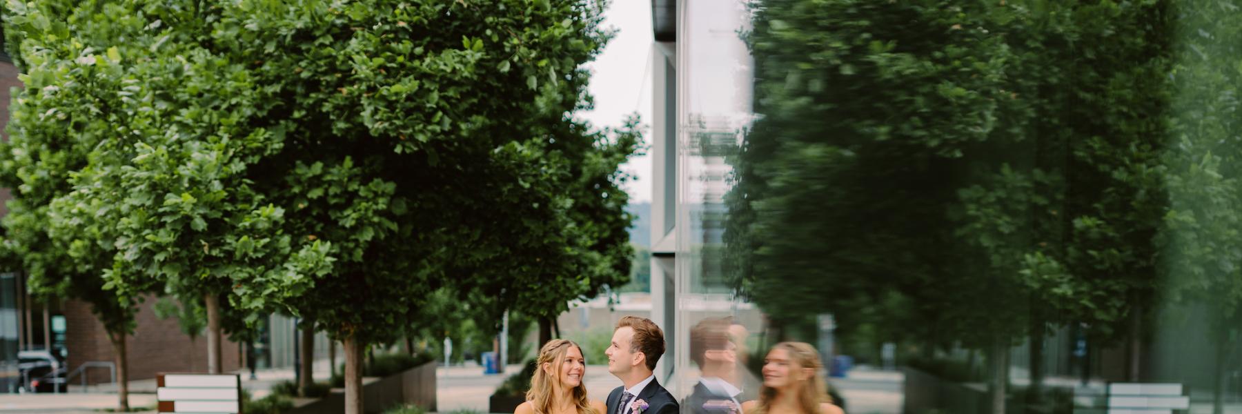 couple standing in front of mirrored building