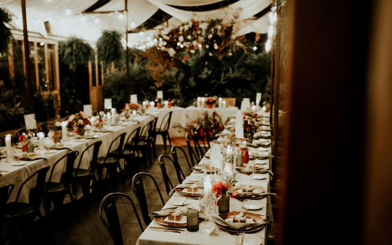 wedding reception tables with candles, flowers, and table settings