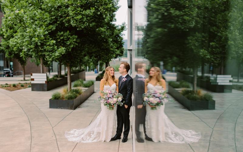 couple standing in front of mirrored building