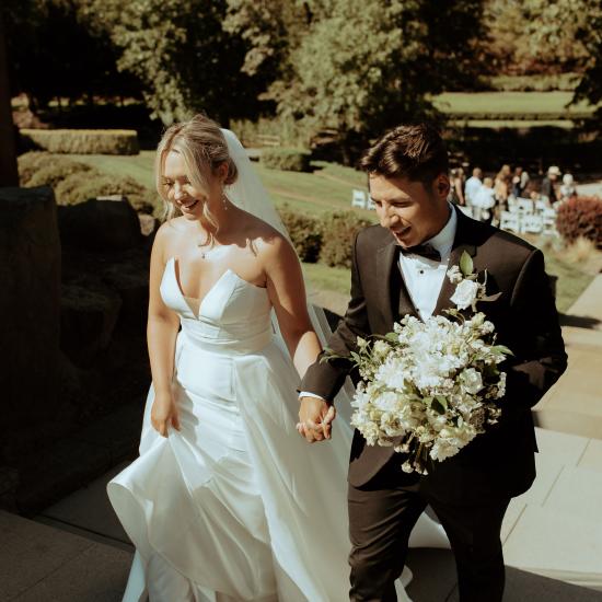 H and C walking up steps from ceremony