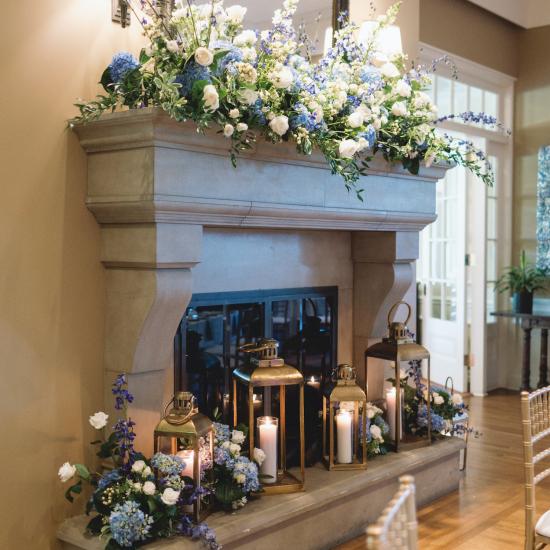 mantel installation with arrangements and lanterns at base