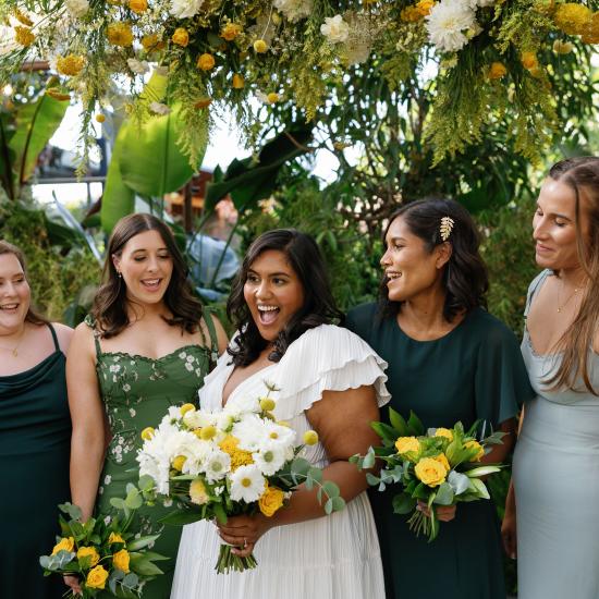 bridesmaids and bride under flower cloud